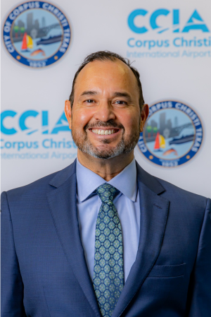 Professional headshot of Ricardo Talavera against an Airport logo background, smiling.