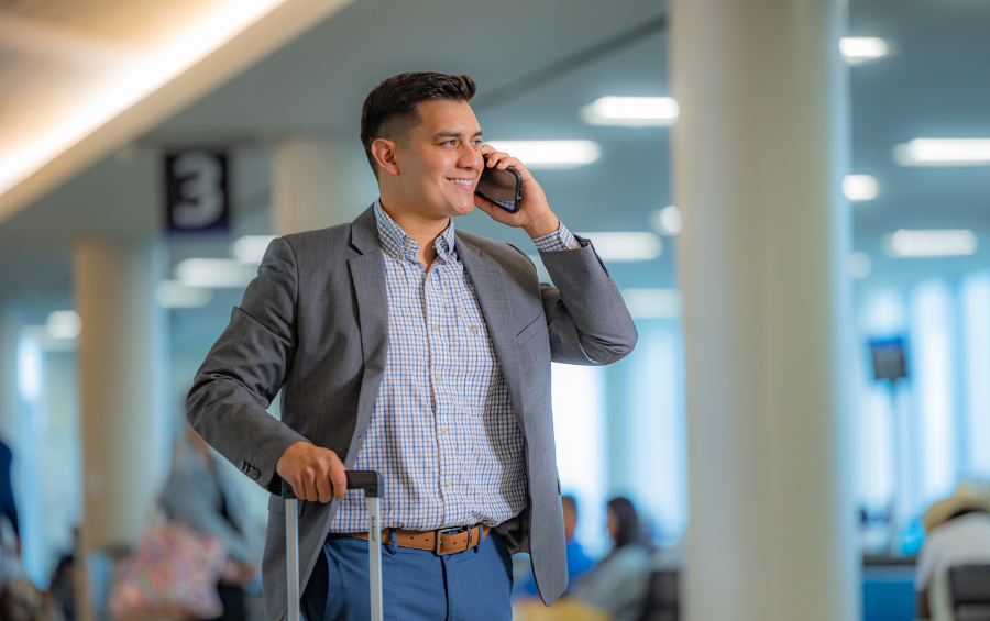A young man on the cell phone, smiling in the terminal at Corpus Christi International Airport.