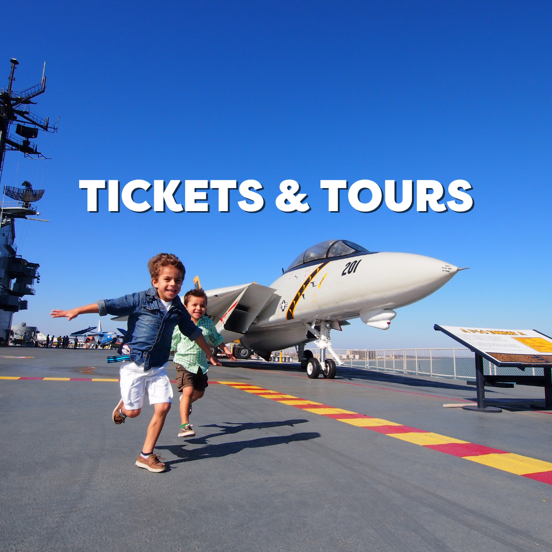 Ticket & Tours - Children running joyfully on an aircraft carrier deck with a fighter jet and blue sky in the background
