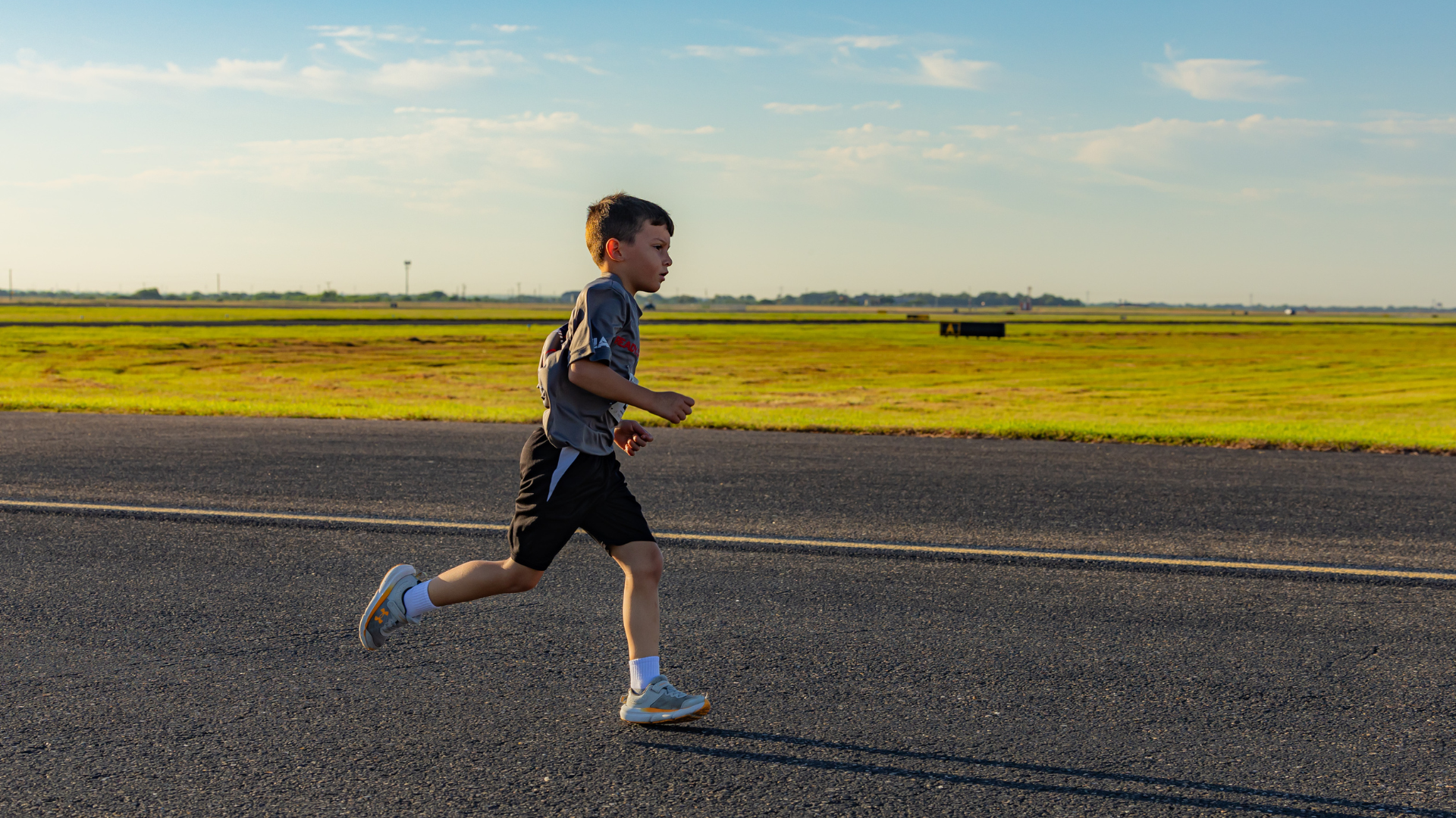 young boy running on the airport runway